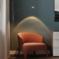 an orange chair sitting in front of a tall lamp