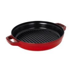 a red cast iron skillet with an oval grill in the center and two handles on each side