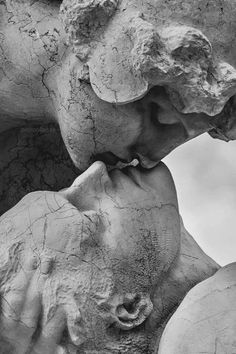 black and white photograph of two sculptures with one being kissing the other's head