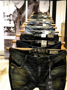 jeans are lined up on display in a store