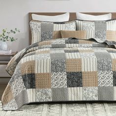 a bed covered in a brown and white checkered comforter next to a night stand