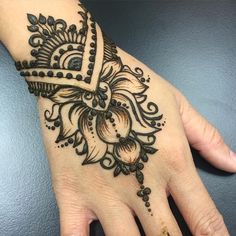 a hand with henna tattoos on it, and an arrow in the middle is shown