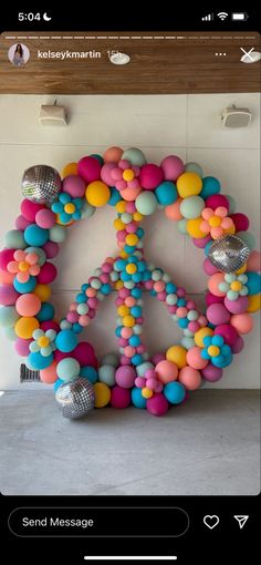 a peace sign made out of balloons and disco balls is displayed on a phone screen