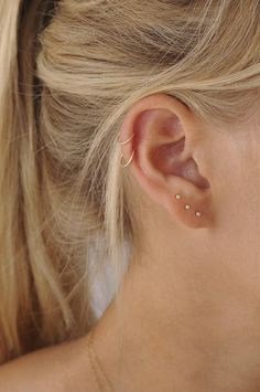 a close up of a woman's ear with two piercings on the side