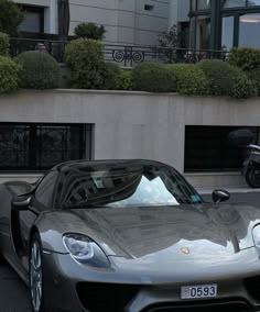 a silver sports car parked in front of a building