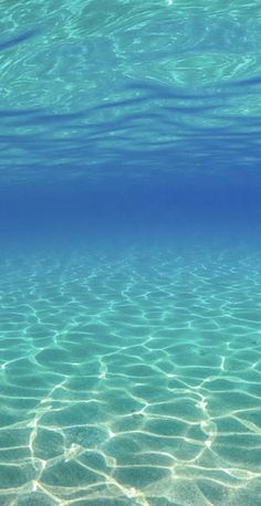 an underwater view of clear blue water with ripples