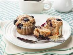 blueberry muffins on a plate with a cup of coffee