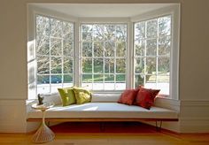 a white couch sitting under a window in a living room