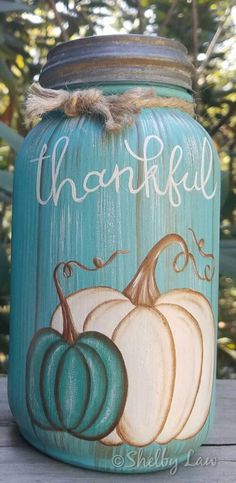 a painted mason jar with pumpkins and the words, thank you all on it