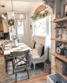 a dining room table and chairs in front of a window with open shelving on the wall