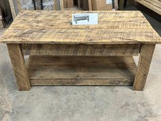 a wooden coffee table sitting on top of a floor next to stacks of wood planks