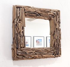 a mirror made out of driftwood is hanging on the wall