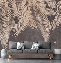 a couch in front of a wall with palm leaves on it