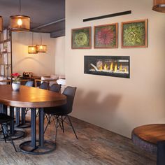 a dining room table with chairs and a fire place on the wall in front of it