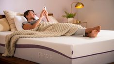 a woman laying on top of a white mattress