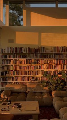 a living room filled with lots of furniture and bookshelves next to a window