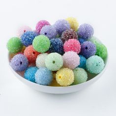 a white bowl filled with lots of colorful candies