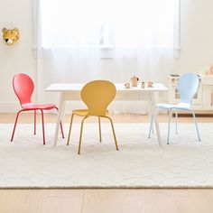 three chairs sitting at a table in front of a white rug with a teddy bear on it