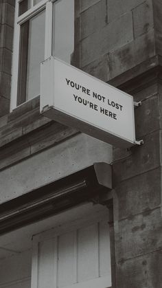 a sign on the side of a building that says, you're not lost you're here