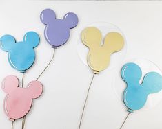 three mickey mouse shaped cake toppers sitting next to each other on a white surface