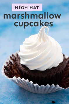 a chocolate cupcake topped with white frosting on a blue background and the words high hat marshmallow cupcakes above it