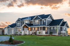 a large house with lots of windows on the front and side of it at sunset