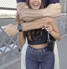 two people are hugging each other on a bridge