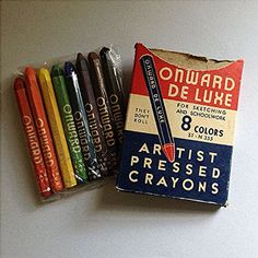 an old box of crayons sitting on top of a white table next to each other