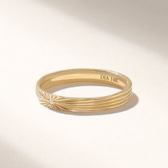 a close up of a gold ring on a white surface with the word dia in it