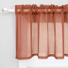 an orange curtain hanging on the side of a window