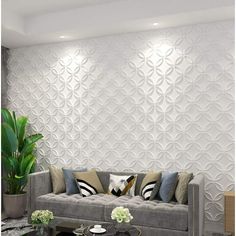 a living room with couches, coffee table and potted plant in front of the wall