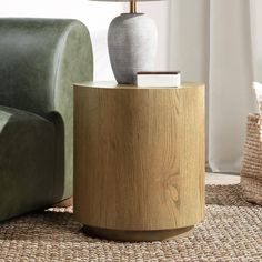 a table with a lamp on top of it next to a green couch and chair