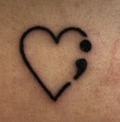 a heart shaped tattoo on the back of a woman's shoulder