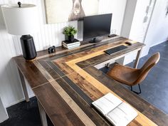 a desk with a computer on it and a lamp next to it in a room