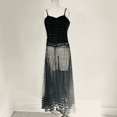 "This gorgeous vintage evening gown from the 1930s exudes old Hollywood glamour. The floor-length skirt is crafted from delicate black lace with six rows of slim black velvet ribbon elegantly trimming the hem. A layer of fine black tulle lies underneath the sheer skirt. The structured bodice features rows of black velvet ribbon sewn over black lace. It has a sweetheart neckline and narrow black velvet shoulder straps.  The back closes with a row of decorative black fabric-covered buttons down the center, with small hidden hooks and eyes sealing securely. Rare and lovely! Fits up to a size Medium. The dress form is X Small, 0 to 2 Measurements with an inch of room for comfort: Bust up to 35\" Waist up to 28\" Hips up to 51\" Exact measurements are taken flat  to compare to a garment that fi Vintage Lace Maxi Party Dress, Vintage Lace Trim Maxi Dress For Evening, Roaring 20s Dresses, Vintage Evening Gowns, 1930's Fashion, Black Velvet Ribbon, Velvet Party Dress, Sheer Skirt, 1930s Fashion