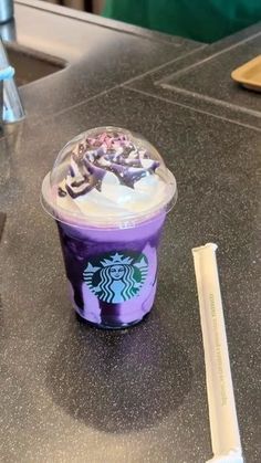 a purple starbucks drink sitting on top of a counter