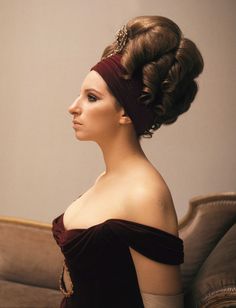 a woman with her hair up in a bun and wearing a red headband, looking off to the side