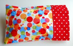 a colorful polka dot pillow on a white background