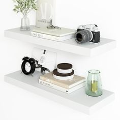 two white shelves with books, camera and other items