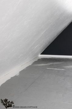 a man riding a skateboard on top of a cement floor next to a white wall