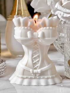 a white candle holder sitting on top of a table