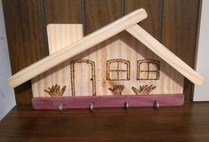 a wooden house with three hooks on it