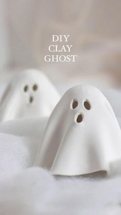 two white ghost figurines sitting on top of a bed with the caption diy clay ghost