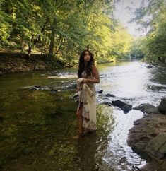 a woman standing in the middle of a river