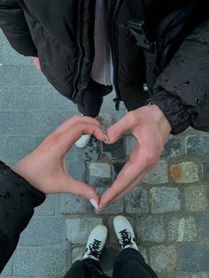 two people making a heart shape with their hands