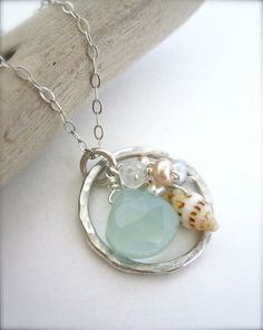 a necklace with sea glass and seashells on it