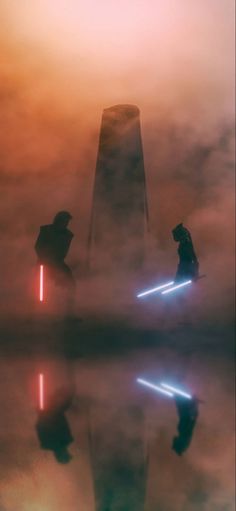 two people with lightsabens standing in the fog near a tower and water puddle