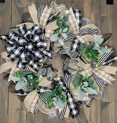 a wreath made out of burlocks and green plants on a wooden floor with ribbon