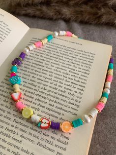 an open book with a colorful beaded bracelet on it