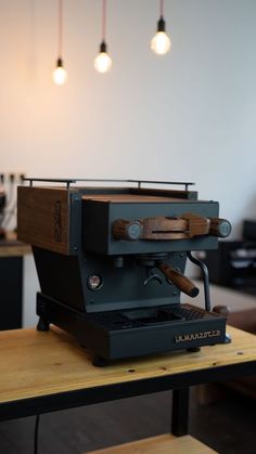 an espresso machine sitting on top of a wooden table in a coffee shop